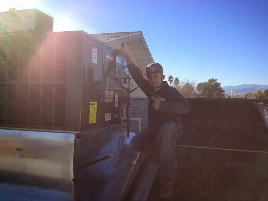HVAC technician performing Air Duct Repair on a rooftop unit in Bethel